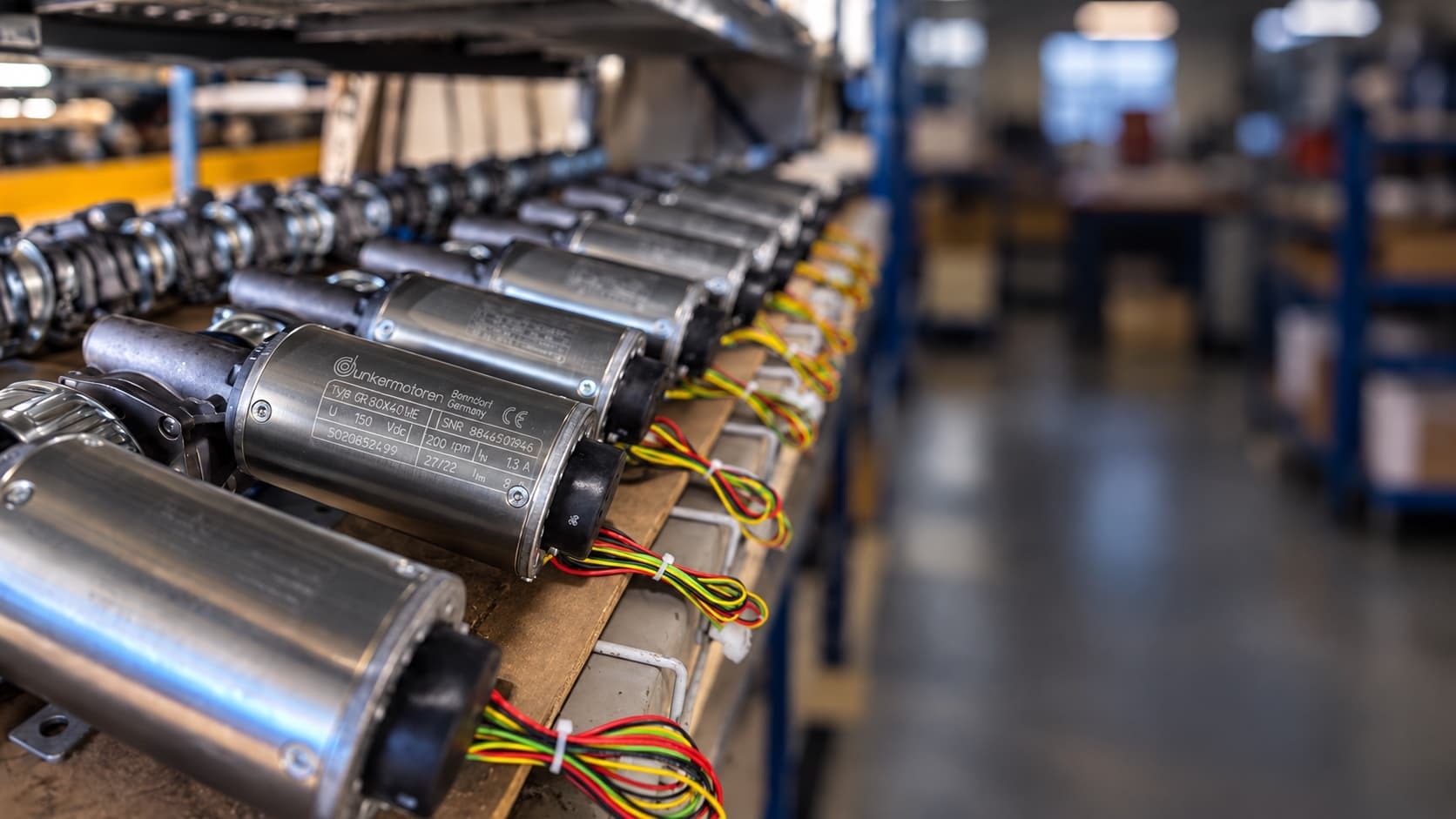 Rows of rebuilt automatic door operator motors on a shop shelf
